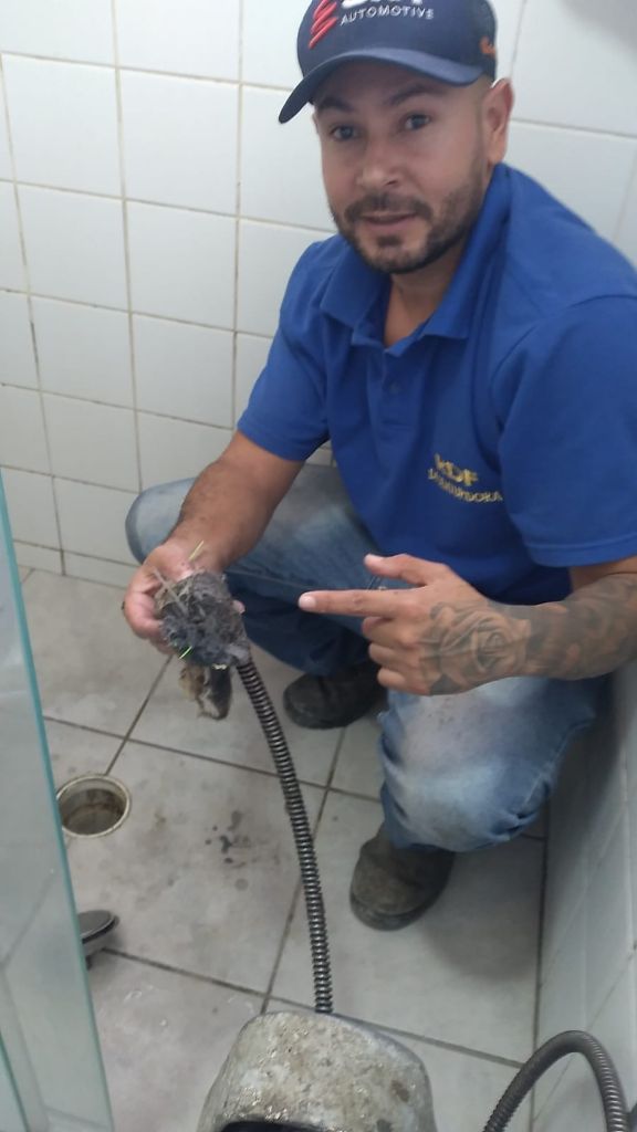 Profissional da RDF após desobstrução de tubulação
