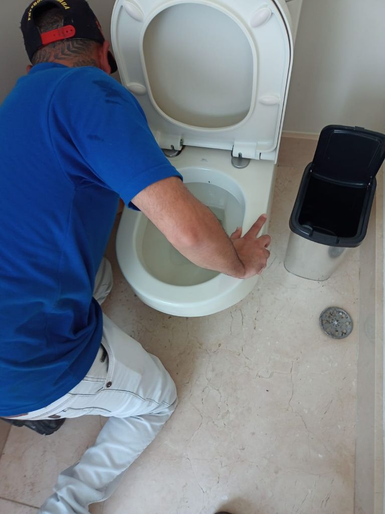 Profissional realizando desentupimento de vaso sanitário